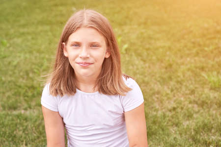 Little girl portrait. Outdoor green background. Looking. Teenager schoolgirl at park. Cute face....