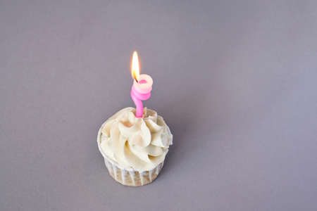 Milky cream cupcake. Birthday sweet bakery. Cookies. Yummy buttercream dessert. Wedding party food. Grey background. Holiday recipe. Anniversary gourmet. One pieces. Candle lightの写真素材