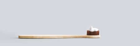 Ecology toothbrush. Sustainable mouth product. Zero waste lifestyle. Organic accessory. Dental health at home. Biodegradable recycle. Grey background. Copyspace. Brow color. Toothpasteの写真素材