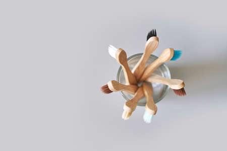 Set of ecology toothbrush on grey background. Different color at glass. Diversity concept. Sustainable mouth product. Zero waste lifestyle. Organic accessory group. Biodegradable recycleの写真素材