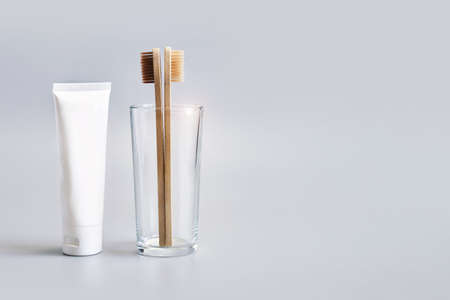 Ecology toothbrush on grey background. Brush in glass. Sustainable mouth product. Zero waste...
