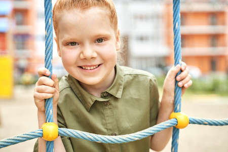 Kid at playground. Pretty face. Cute school child. Active vacation. Small people. Summer freedom. Happy children concept. Lifestyle action. Net parkの写真素材