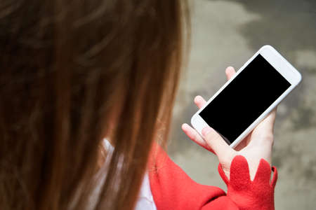 Pretty girl outdoors. Real people using mobile phone. Single female person. Cellphone mockup with...