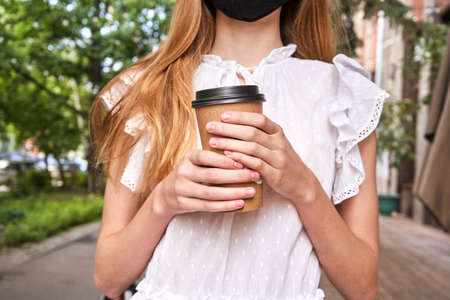 Pretty girl drink beverage outdoors. Buy takeaway coffee in plastic cup.の写真素材