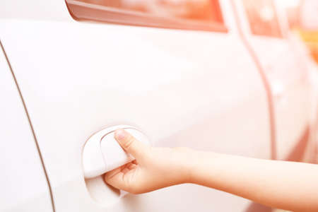 Children hand opening car door. Stole service concept. Criminal lifestyle. Boy enter taxi. Unlock vehicle lockの写真素材