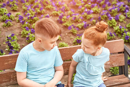 Little girl and boy at backyard. Green casual dress. Family outdoor portrait. Female and male children. Summer day. Happy sibling faces. Friendship concept.の写真素材