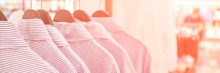 Clothes market interior. Blur light background. Shop shelf. Stock shirts. Perspective mall hall. Supermarket wallpaper. Copyspace. Horizontal. Casual lifestyle marketの写真素材