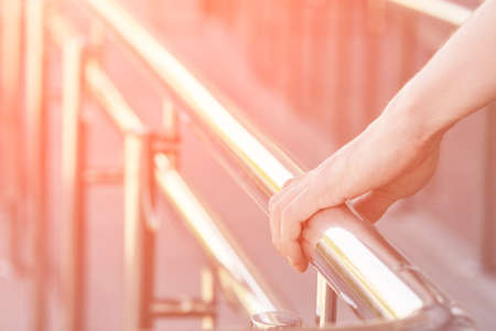 Hand using handrail for wheelchair. Man support. Steel construction. Mall escalator safety guard. Disabled rampの写真素材