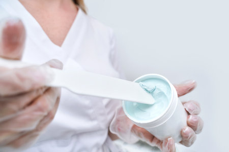 Cosmetology beauty procedure. Woman skin care. Beautiful female person. Rejuvenation treatment. Facial chemical peel therapy. Clinical healthcare jar. Doctor hand. Dermatology cleanser. Product bowlの写真素材