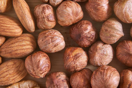 Many different nuts. Assortment healthy snacks. Mediterranean diet. Dry vegan charcuterie. Variety party pile. Kitchen table. Fat nutrients. Almonds, hazelnutsの写真素材