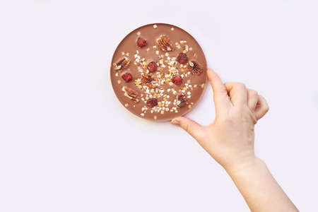 Hand made swiss milk chocolate. Christmas brown textured bar. Top view. Pecan, cranberry, nuts. Handcrafted dessert. Sweet christmas food. Sugar and cacao candy giftの写真素材