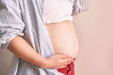 Pregnant skin care. Morning body routine. Woman belly. Female person drainage massage. Anti cellulite cosmetology treatment. Waiting babyの写真素材