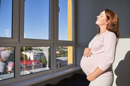 Pregnant skin care. Morning body routine. Woman belly. Female person drainage massage. Anti cellulite cosmetology treatment. Waiting babyの写真素材