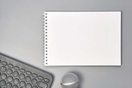 Podcast concept. Black microphone, content notebook. Close up. Audio music device. Recording production. School knowledge equipment. Home online teaching mockup. Grey backgroundの写真素材