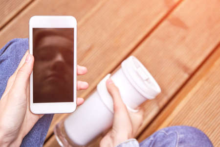 Pretty girl outdoors. Real people using mobile phone. Single female person. Cellphone mockup with...