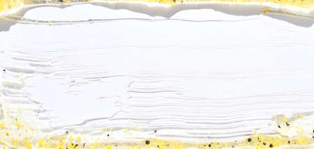 Face scrub texture. Cream skincare cosmetic. Organic stroke. Feet oily cleanser smudge. Particles in gel. White background. Top view. Yellow and black fluid treatmentの写真素材