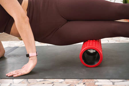 Young woman stretch body on fitness mat. Myofascial release massage. Relax pilates. Home pain...