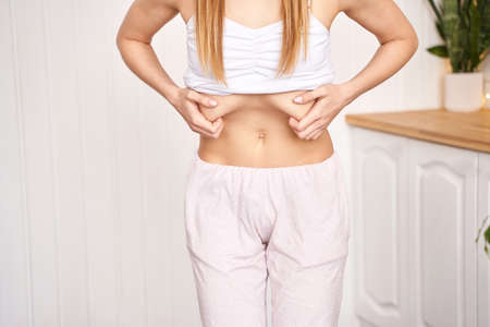 Young pretty woman do breathing exercise. Home sport workout. Healthy lifestyle. Long hair. Female person body. Vacuum yoga belly gymnastics. Lock abdominal. Nauli active positioin. Abs muscleの写真素材