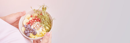 Pregnant woman eating healthy food. Organic calcium salad with fruits and microgreen. Round plate. Home dinner or lunch. Vitamin cereal. Holding bowl in hands.の写真素材