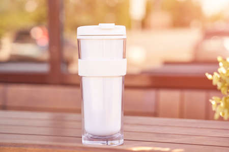 Drink beverage outdoors. Buy takeaway coffee in own cup. Ecology concept. Sustainable lifestyle. White tumbler mug. Zero waste reusable cupの写真素材