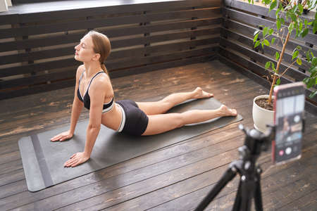 Young woman going yoga exercise at home.