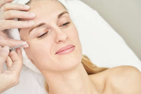 Injection at spa salon. Doctor hands in gloves. Closeup. Pretty female patient. Beauty treatment....