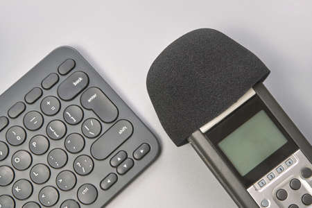 Podcast concept. Black microphone recorder, content notebook keypad. Close up. Audio music device. Recording production. School knowledge equipment. Home online teaching. Greyの写真素材