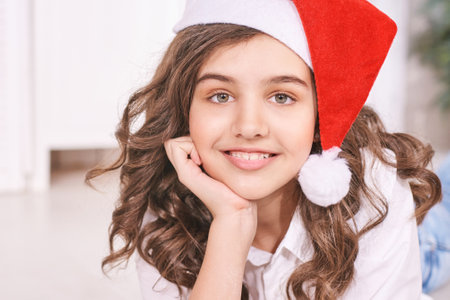 Young girl at kitchen. Christmas hat. studio portrait. Curly pretty child. Student looking at camera. Attractive brunette. Children emotionの写真素材