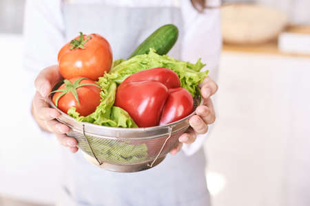 Young girl cooking at kitchen with vegetables. pretty child portrait. Chef student. Attractive brunette. Children emotion. People baking in cook apron. Close recipe menuの写真素材