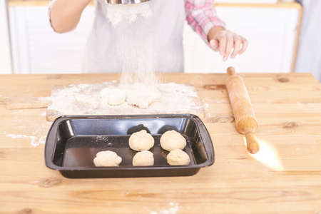 Young girl cooking at kitchen. Curly pretty child portrait. Chef student. Attractive brunette. Children emotion. People baking in cook apron. Close recipe menuの写真素材