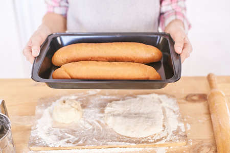 Young girl cooking at kitchen. Curly pretty child portrait. Chef student. Attractive brunette. Children emotion. People baking in cook apron. Close recipe menuの写真素材