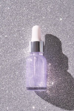 Transparent purple bottle of moisturizing serum with pipette. Skin care routine. Sparkles bubbles. Face product. Liquid oil essence. Beauty Vitamin collagen. Organic peeling treatment. Body healthの写真素材