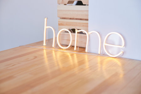 Minimalist bedroom with soft lighting and stylish bedside lamp against warm textured wallの写真素材