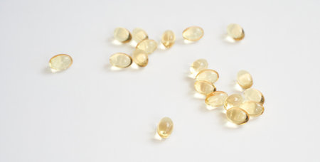 Scattered transparent gel capsules on white surface highlight nutritional health and wellness trendsの写真素材