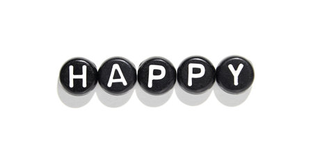 Black stones with white letters forming the word happy on white background with shadowsの写真素材