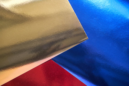 Vibrant metallic foil backgrounds with gold, blue, and red reflective textures for creative design inspiration.の写真素材