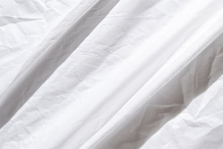 Abstract white wrinkled fabric texture with soft light and subtle shadows for minimalist design...