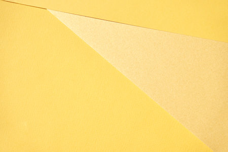 Abstract composition with overlapping yellow textured paper layers creating geometric shapes in minimalistic design.の写真素材