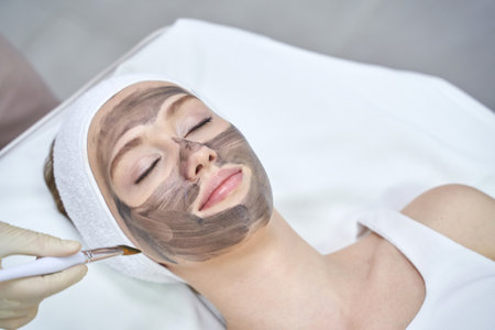 Rejuvenating facial treatment with clay mask at spa for relaxation and skincare.の写真素材