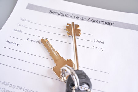 Keys on residential lease agreement document in real estate contract and housing conceptの写真素材