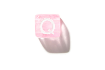 Pink transparent letter q block isolated on white background with shadow.の写真素材