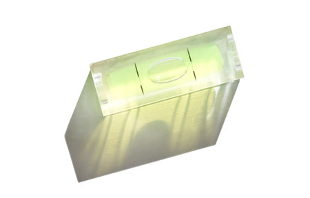 Precision tool with bubble level indicator casting shadow on white background.