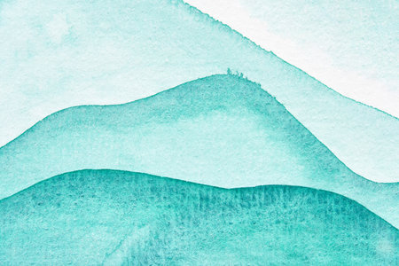 Abstract watercolor artwork featuring soft teal and aqua tones in layered wave patterns.の写真素材
