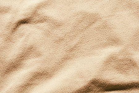 Close up texture of beige fabric with soft wavy patterns and shadow highlights.の写真素材