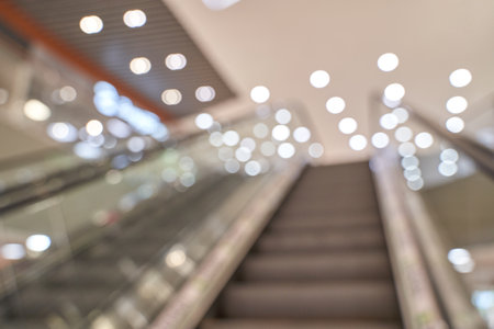 Abstract defocused lights and blurred escalator in modern shopping mall with bright glow.の写真素材