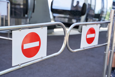 No entry signs on metal gates at public transit station.