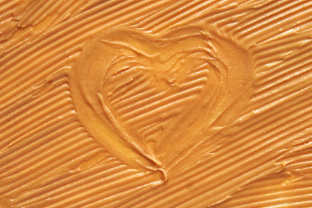 Smooth peanut butter with heart shape imprint reflecting love and care in food preparation.