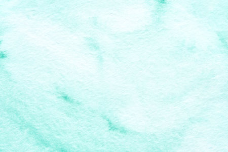 Mint green watercolor background with soft textured patterns for creative design projects.の写真素材