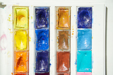 Vibrant palette of dried watercolor paints in various colors.の写真素材