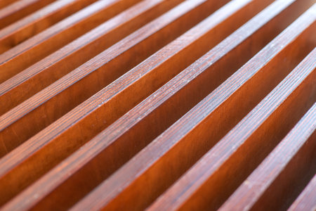 Close-up of wooden slats with regular pattern and warm natural tones in abstract design.の写真素材